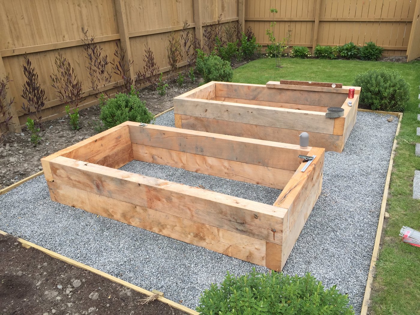 Two timber raised beds during the build, set out on a gravel base